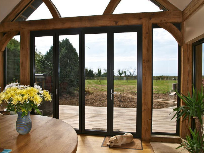 Inside a woodgrain foil aesthetic home extension with black Aluminium Bifold Doors in Carmarthen