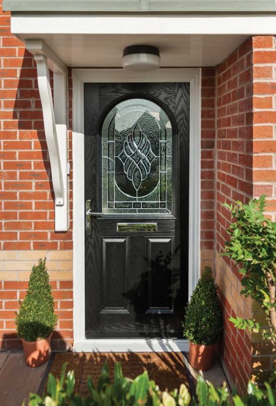 traditional looking black composite door with a large decorative stained glass pane in the centre in cardigan wales