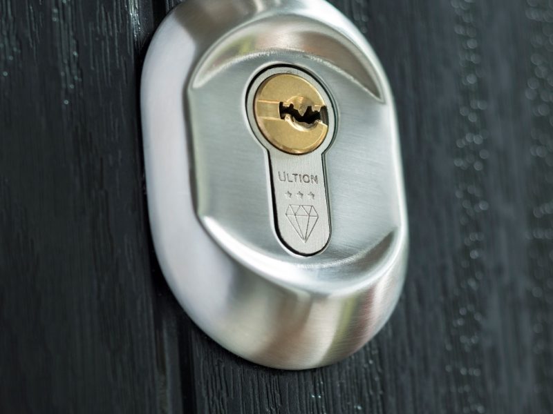 Silver Ultion lock on a black composite door close up