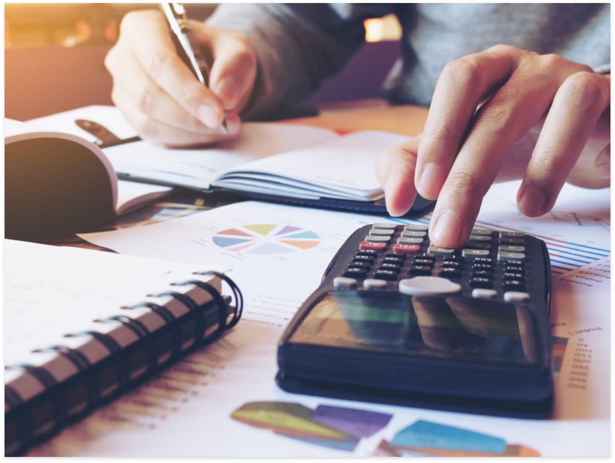 person using a calculator and pen